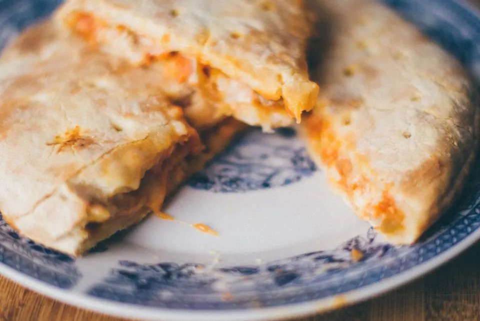 A folded calzone cut open on a plate