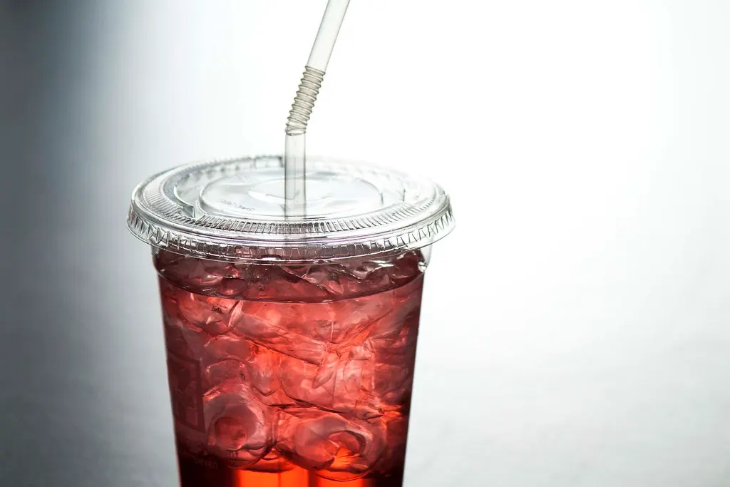 A takeaway cup of iced drink with a straw