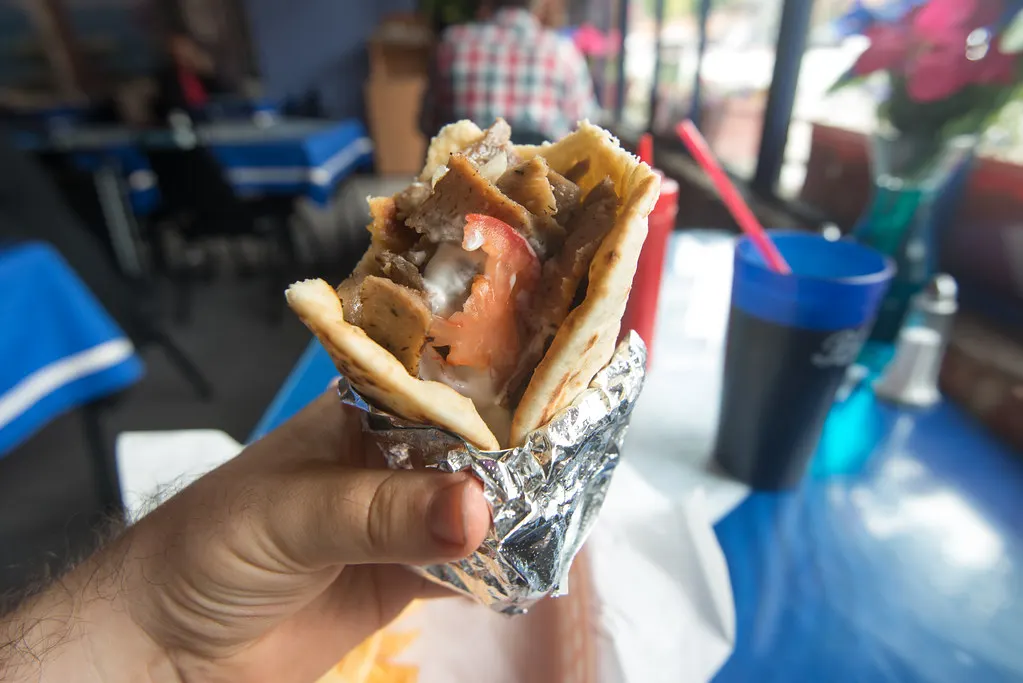 A doner kebab wrap held in the hand
