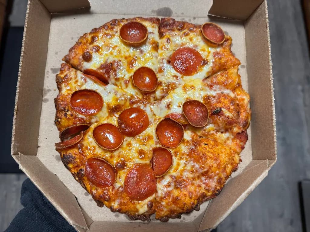 A pepperoni pizza topped with slices of salami